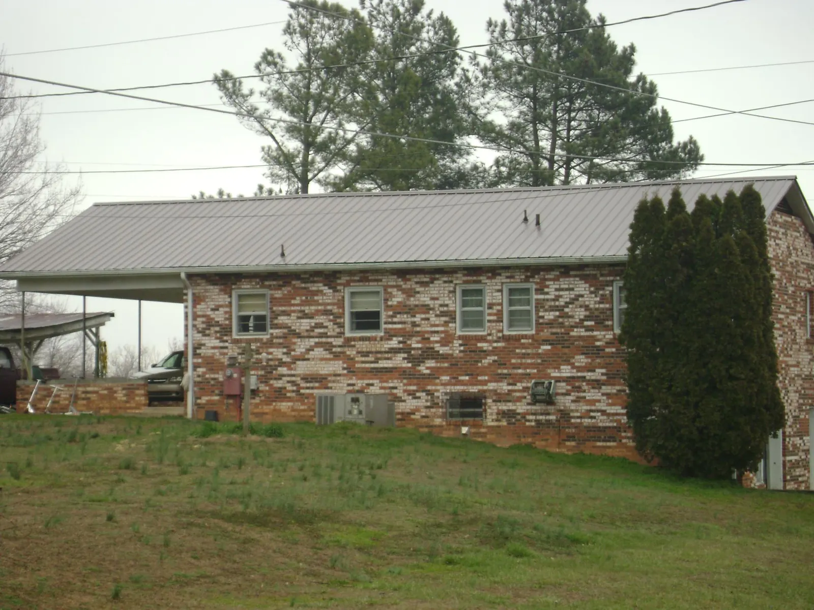 Gray metal roof on a brick split level home with a carport in Portage